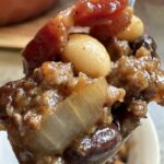 Baked beans with ground beef on spoon