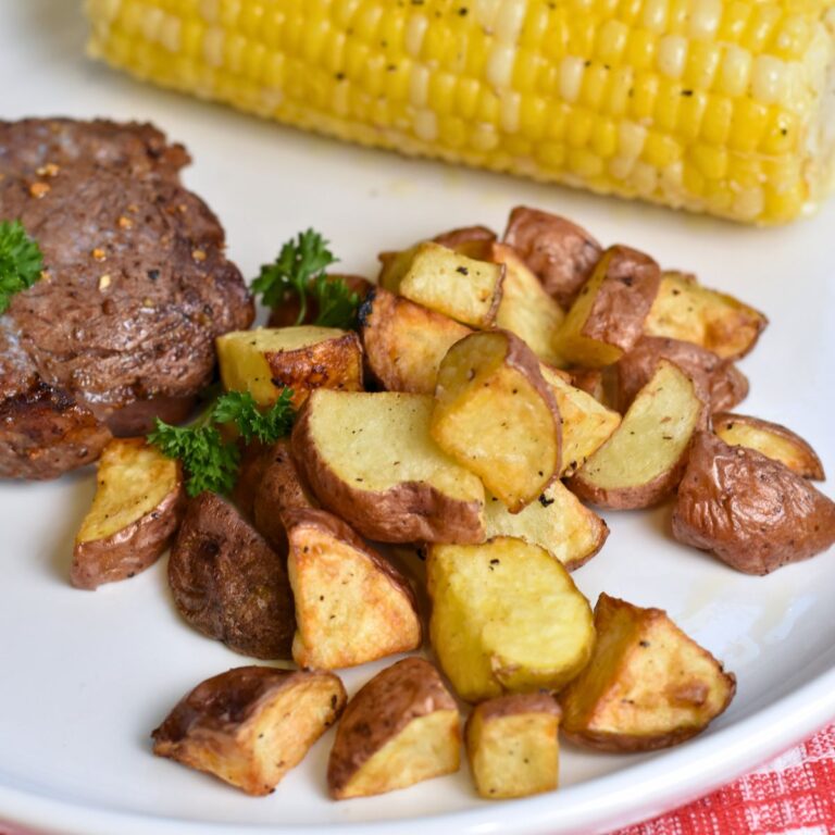 Serving the red potatoes in the air fryer with steak and corn.
