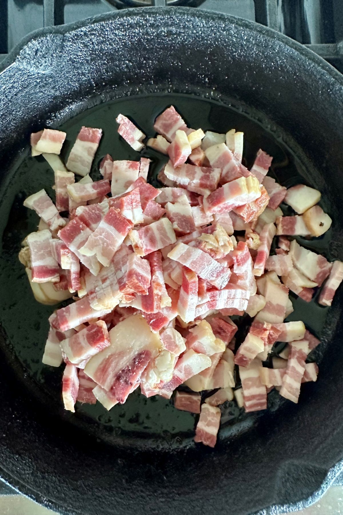 Raw diced bacon in a pan.