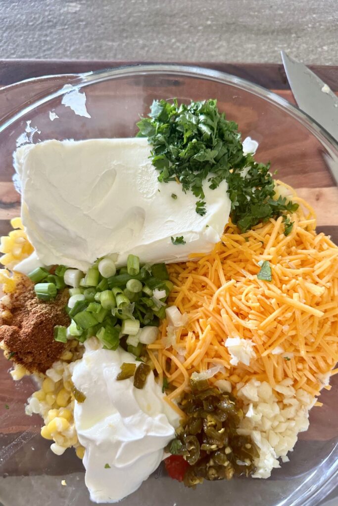 Cream Cheese Corn Dip ingredients in a glass bowl.
