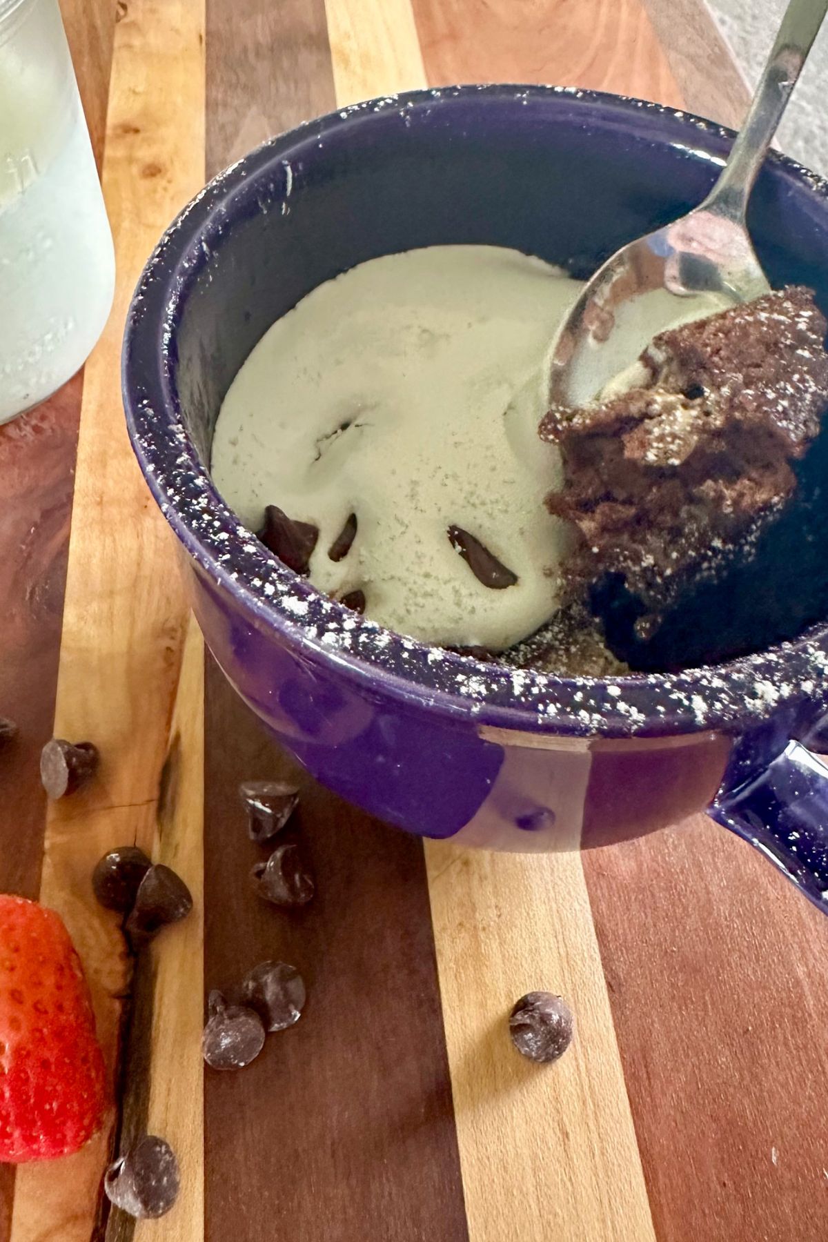 Hot Chocolate Mug Cake with a glass of milk and a strawberry.