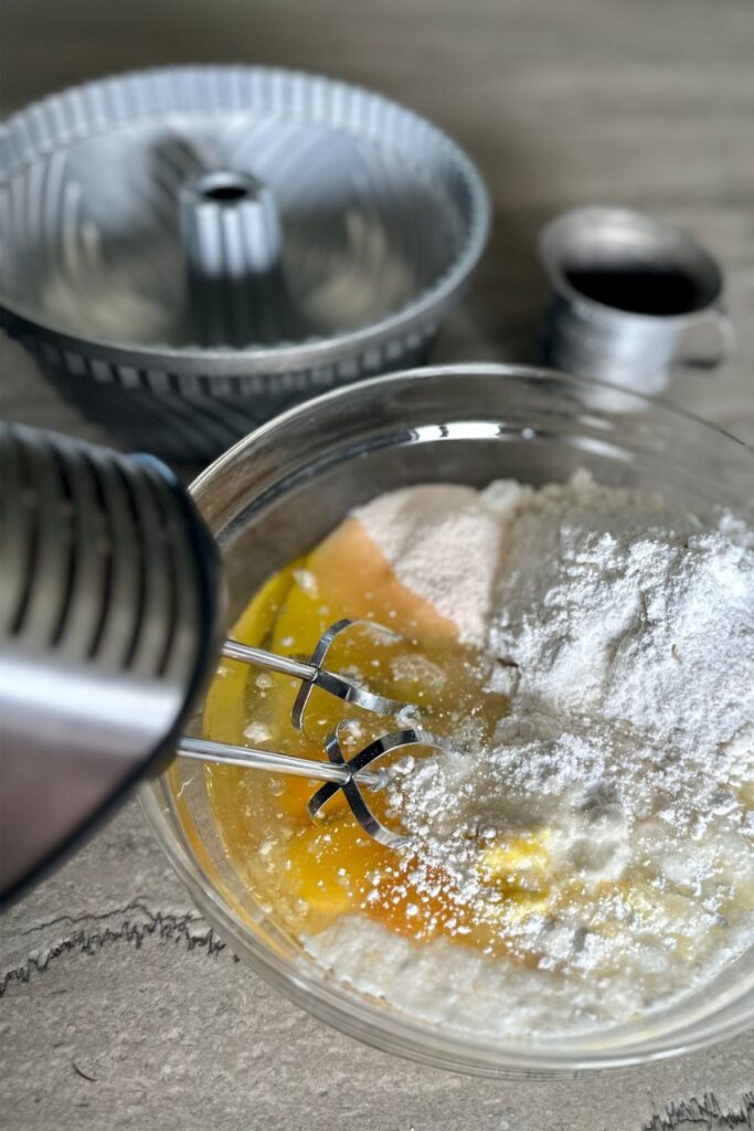 using-my-hand-mixer-to-mix-all-of-the-ingredients-together Mixing bowl and mixer with Jello Lemon Cake ingredients.