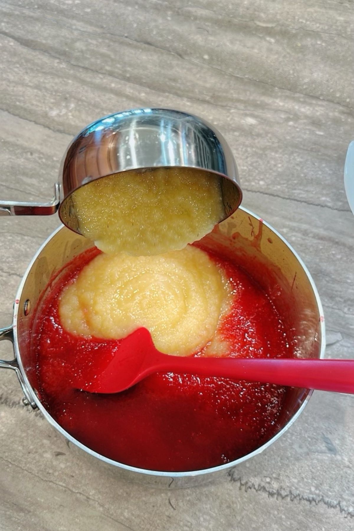 Adding applesauce to pot.
