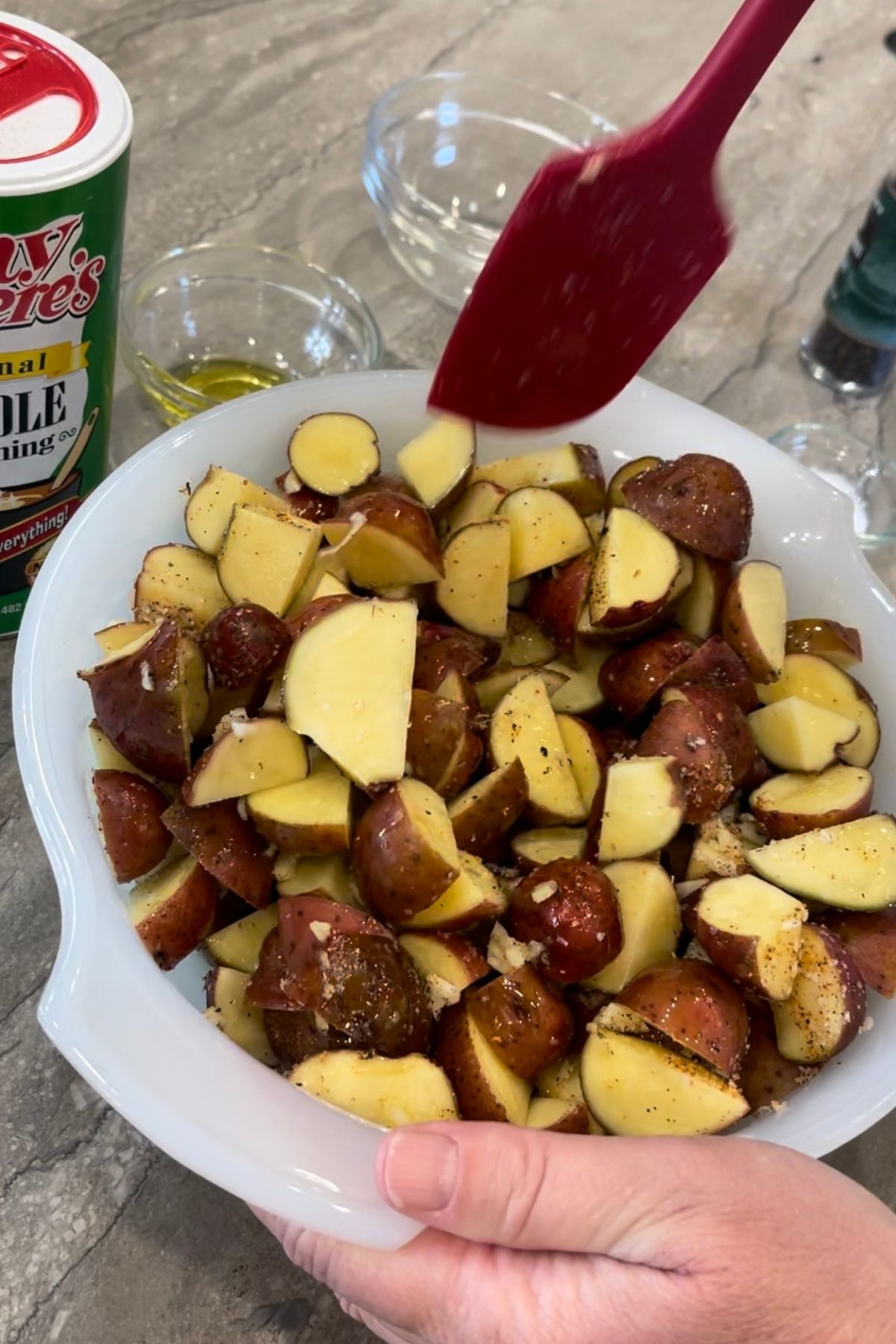 Red potatoes coated in oil and seasonings.