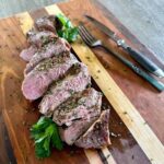 Sliced Sous Vide Pork Tenderloin with knife and fork.