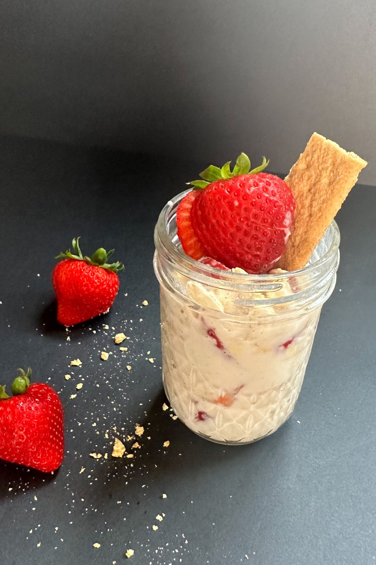 Jar of Strawberry Cheesecake Oats with strawberries.