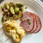 Plate of 3 Ingredient Ham Glaze with mashed potatoes and brussels sprouts.