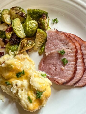 Plate of 3 Ingredient Ham Glaze with mashed potatoes and brussels sprouts.