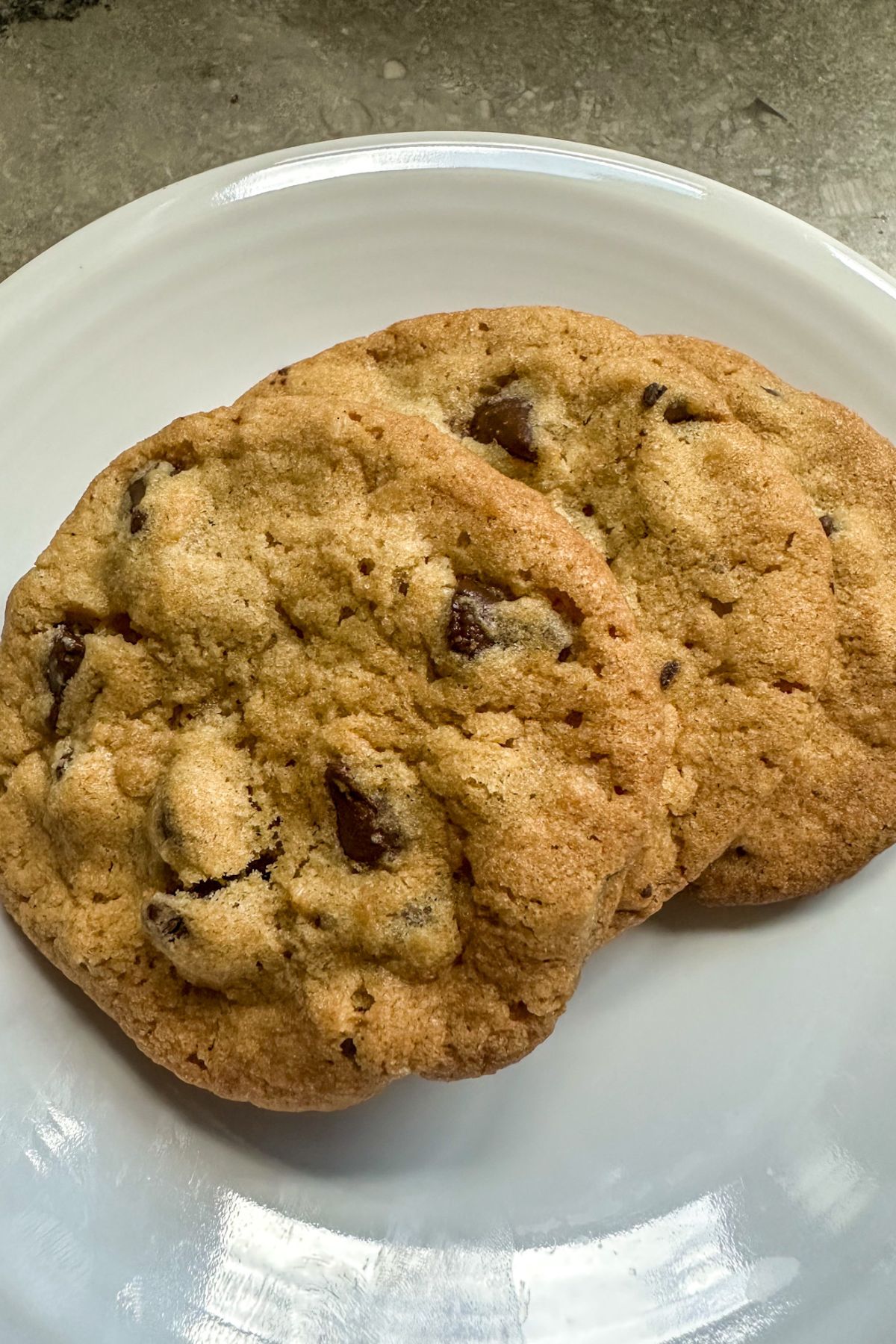 Two Bacon Grease Chocolate Chip Cookies on a plate. 