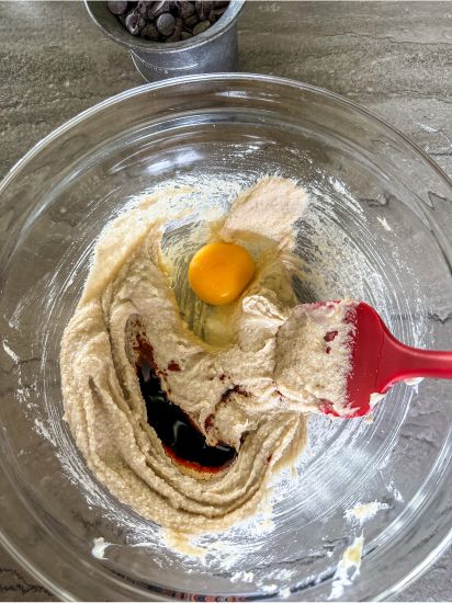 Adding egg and vanilla into cookie batter ingredients. 