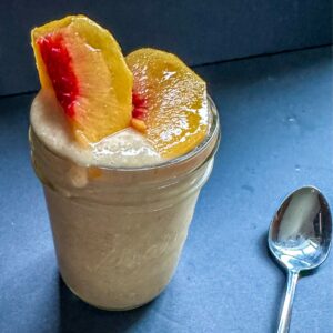 Blended Overnight Oats with peach slices on top.