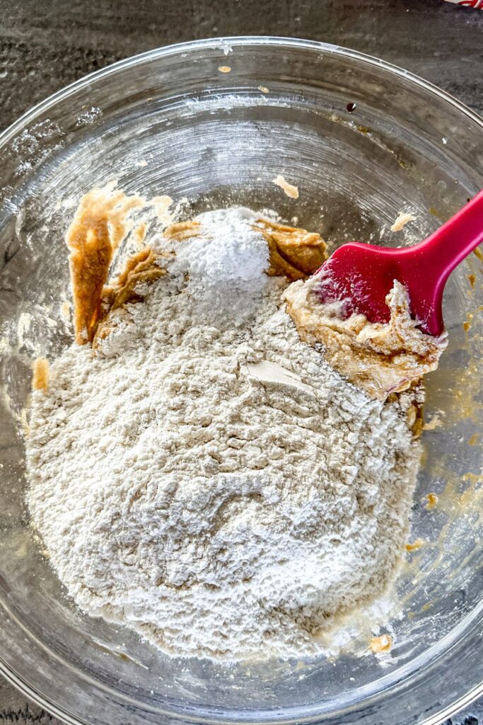 Incorporating flour into the cookie dough batter. 