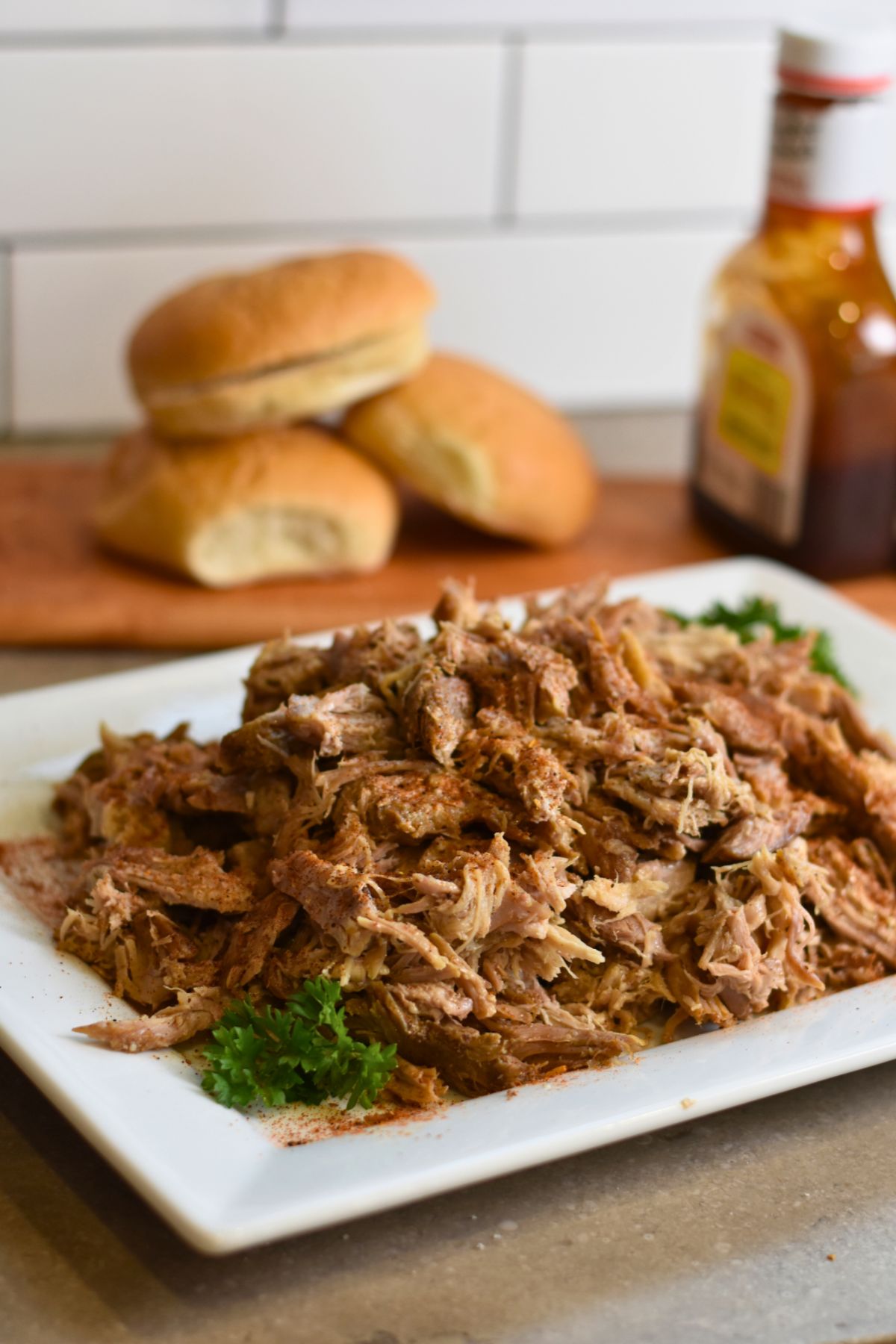 Serving the pork butt on a white platter.