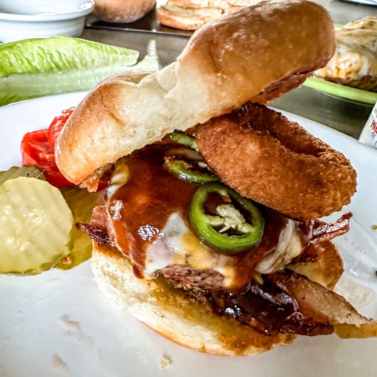 Rodeo Burger on a plate with sliced pickle.