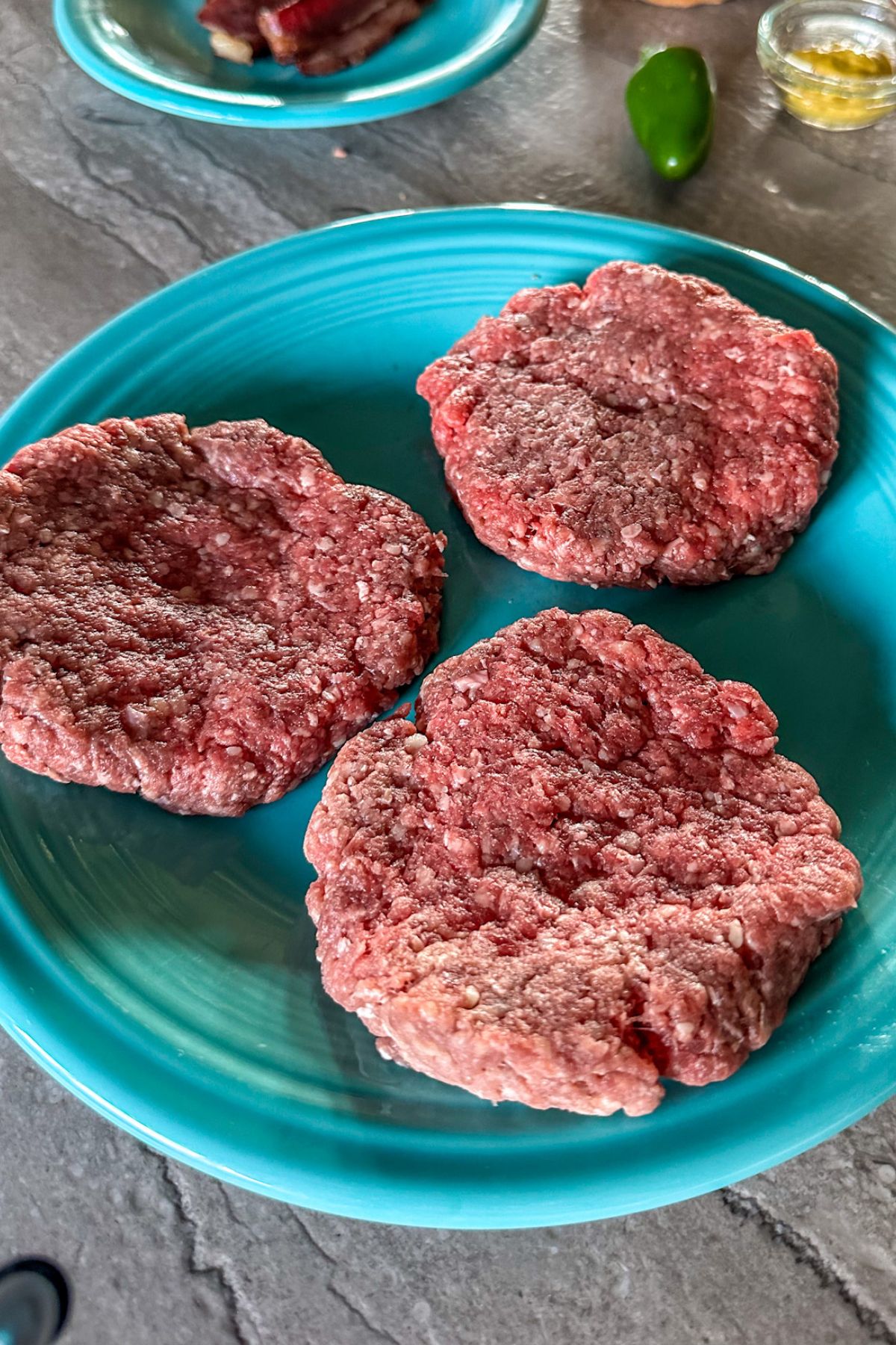 Three beef patties on a plate.