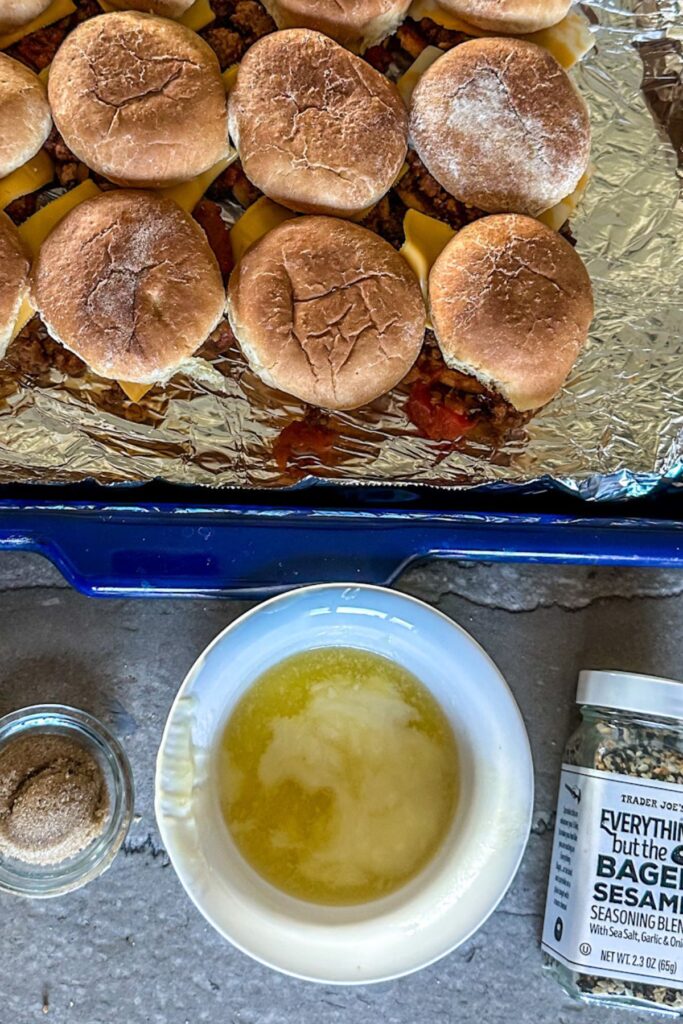 Sheet of Sliders with a bowl of melted butter, brown sugar, and Everything but the Bagel Seasoning.
