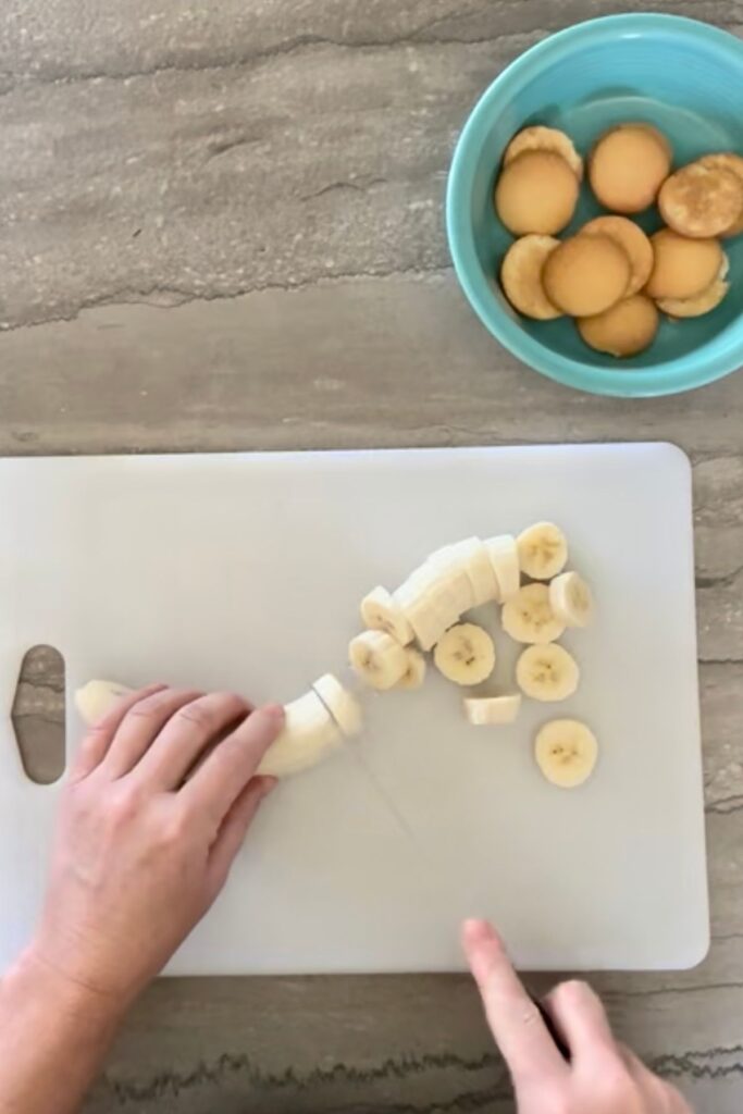 Slicing bananas on a cutting board.