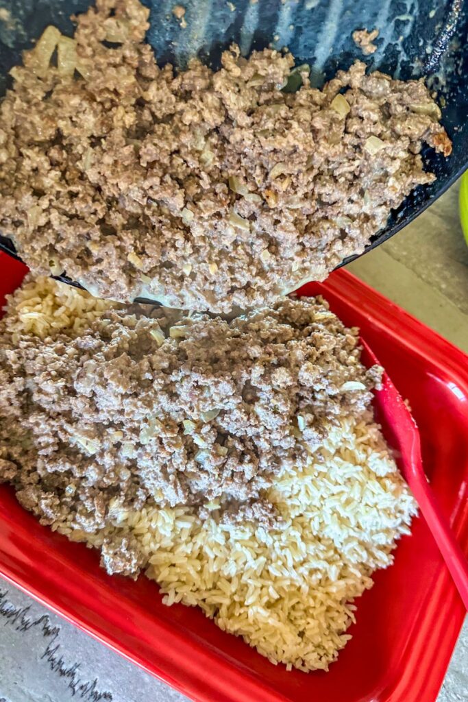 pour-the-ground-beef-over-the-cooked-rice-in-the-casserole-dish pour the ground beef over the rice in the casserole dish.