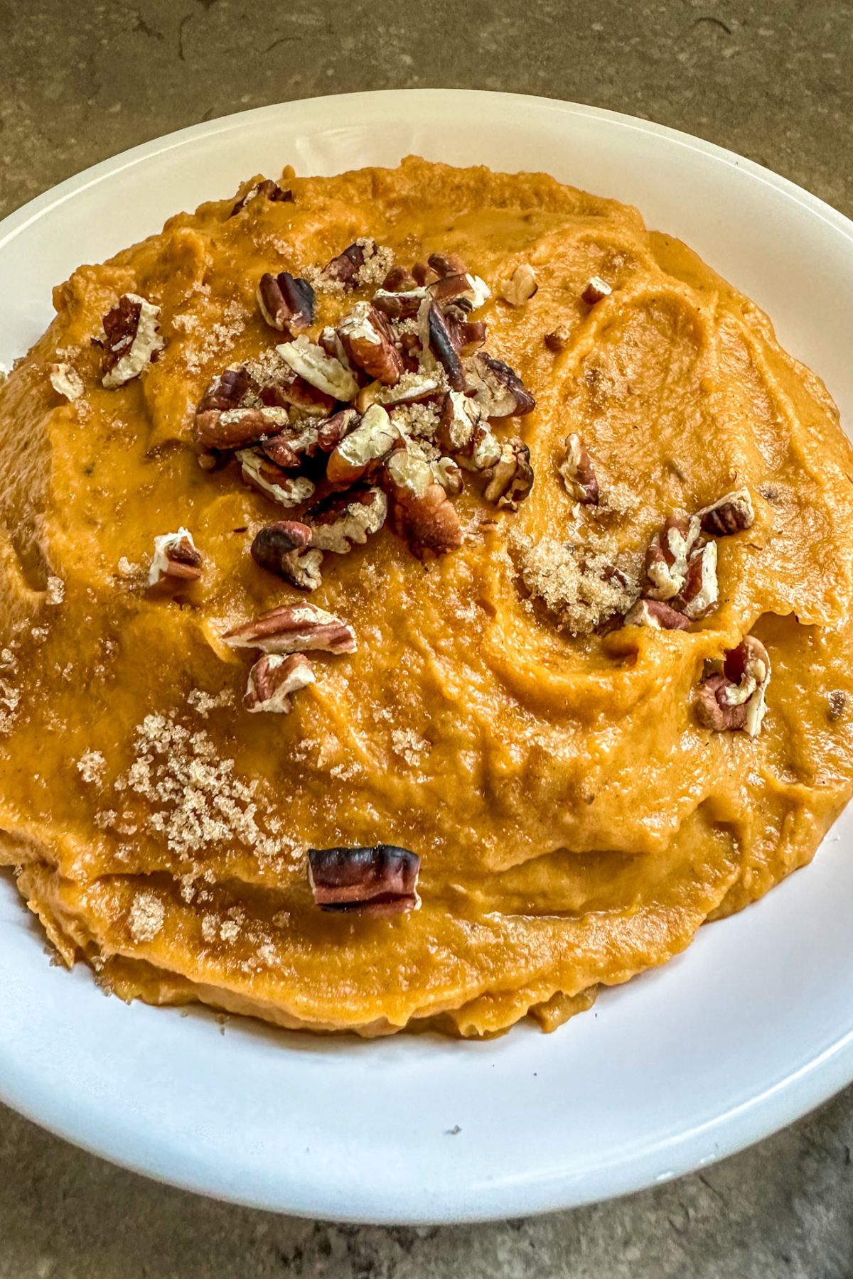 Plated sweet potatoes with pecans on top.