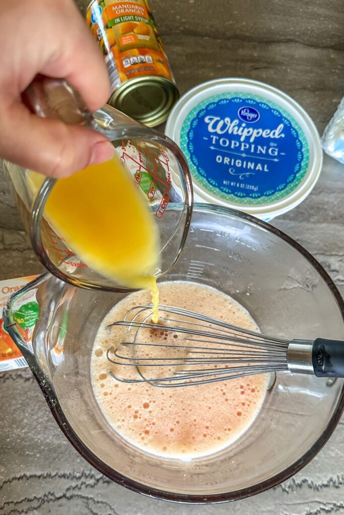 Adding orange juice into the orange Jello mixture. 