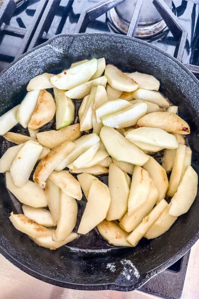 cut and peeled apples in an iron skillet.