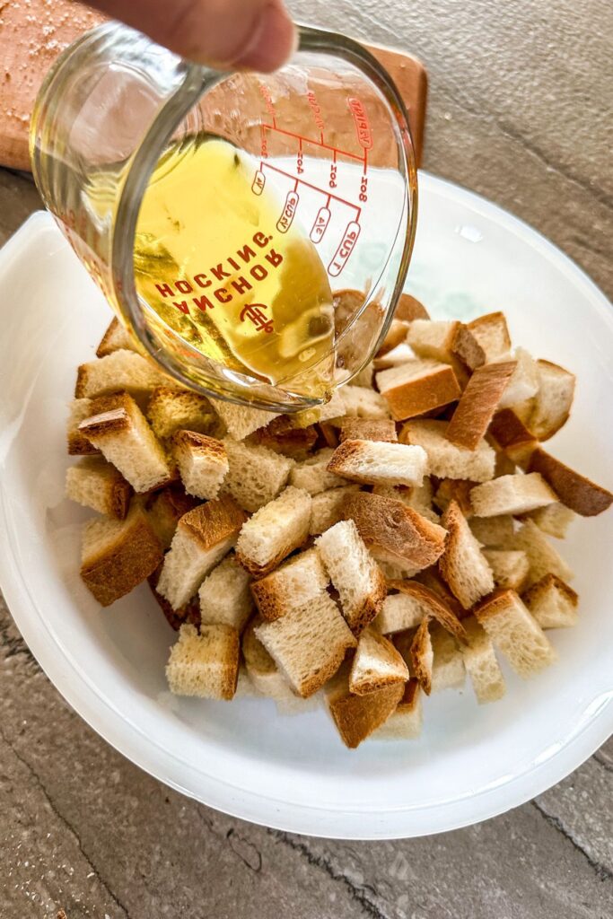 adding oil to bread for air fryer croutons.