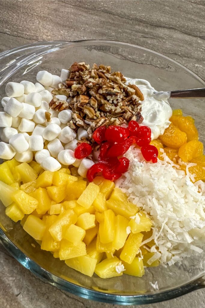 adding all of the ingredients for best ambrosia salad.
