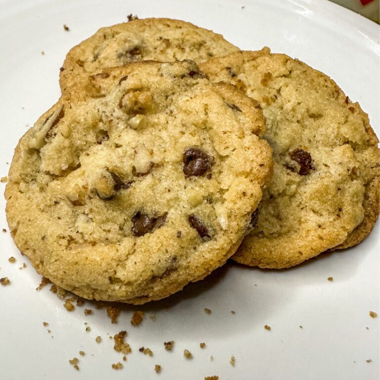 chocolate chip pecan cookies are being served on a white plate.