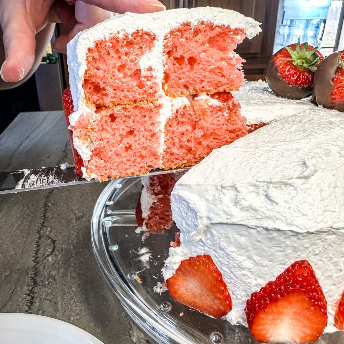 serving easy heart-shaped cake with strawberries in the middle.