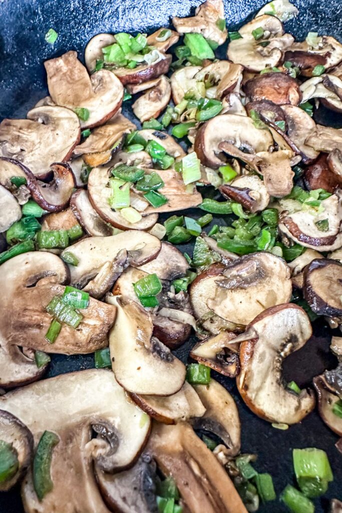 cooking mushrooms, green onions, and jalapenos for vegetarian burgers.