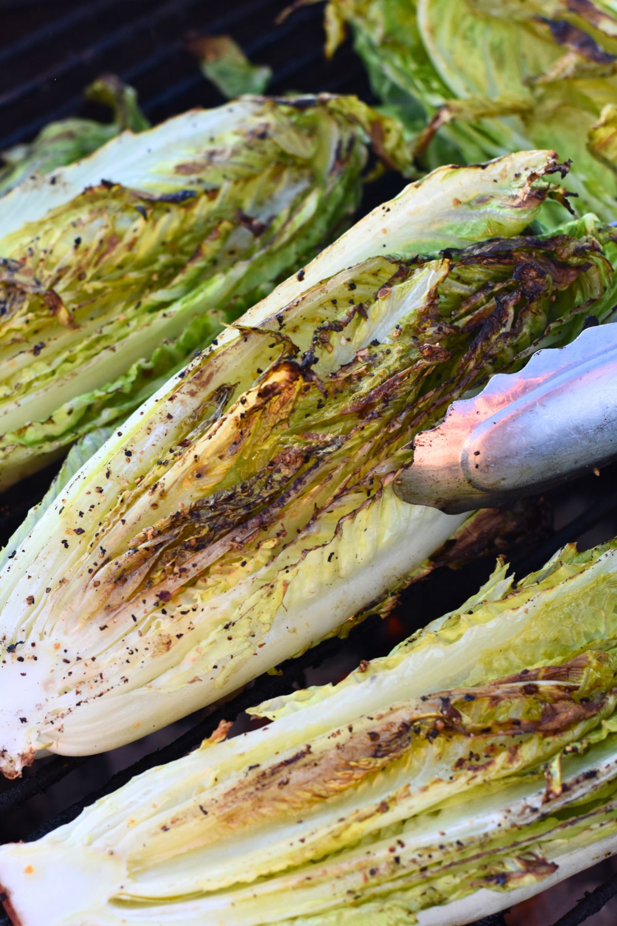 ready-to-eat-grilled-romaine-salad Turning the lettuce on the grill to be served to barbecue guests