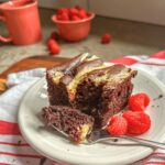 chocolate cake with cream cheese filling on a white plate.