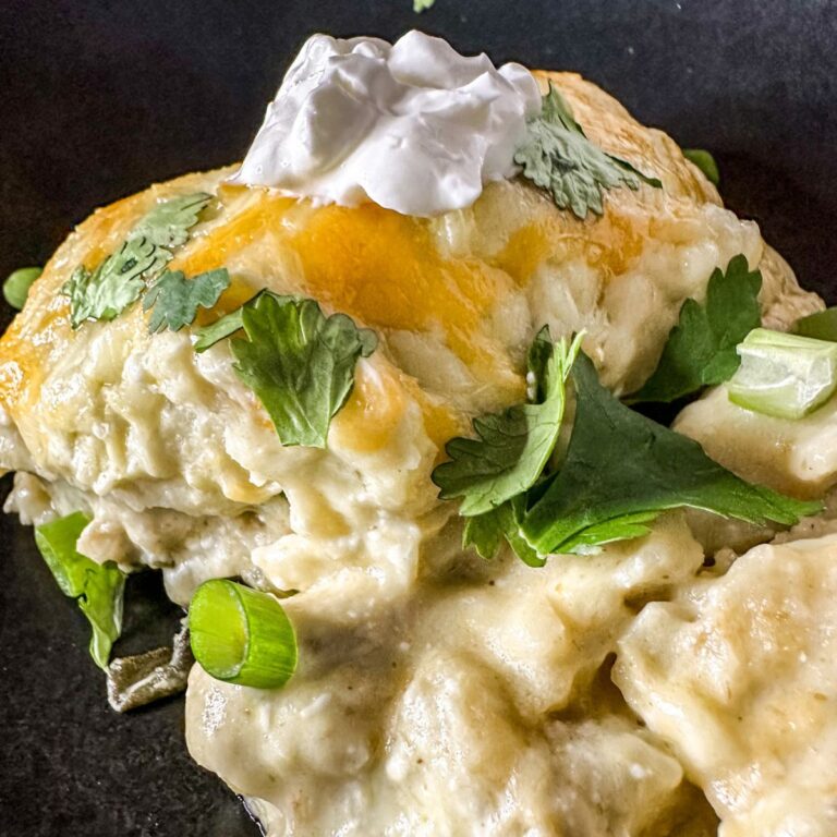 creamy chicken and spinach enchilada casserole topped with sour cream.