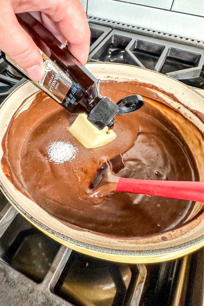 finishing-the-chocolate-pudding-by-adding-butter-vanilla-and-salt adding vanilla, butter, and salt to the chocolate pudding mixture for the chocolate cream pie.
