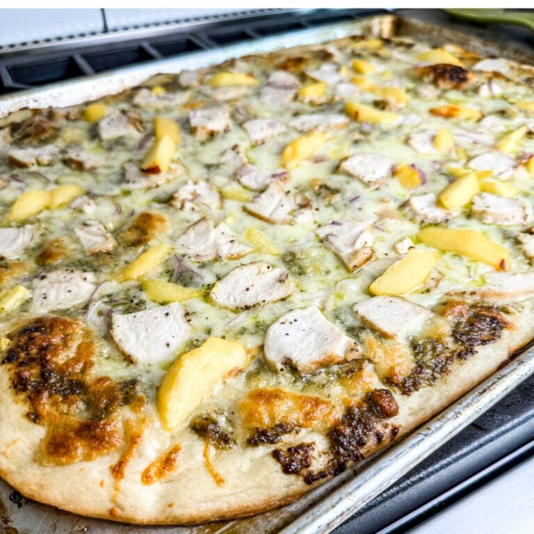 Finished chicken and peach pesto pizza made in a sheet pan ready to serve.