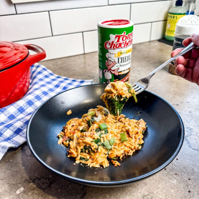 Eating Cajun Chicken Orzo in a black bowl with a sliver fork.