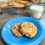 Cornflake crunch cookies served on a blue plate with milk.
