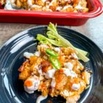 Buffalo chicken tater tot casserole finished and served on a grey plate.