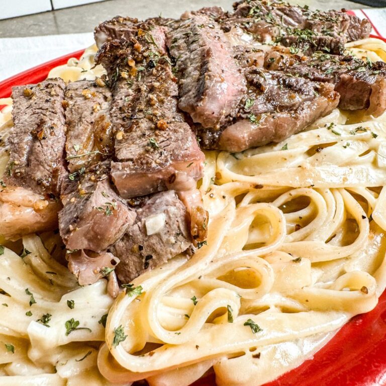 Creamy fettuccine alfredo with steak served with steak.
