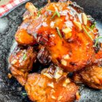 Finished pig wings served in an iron skillet.