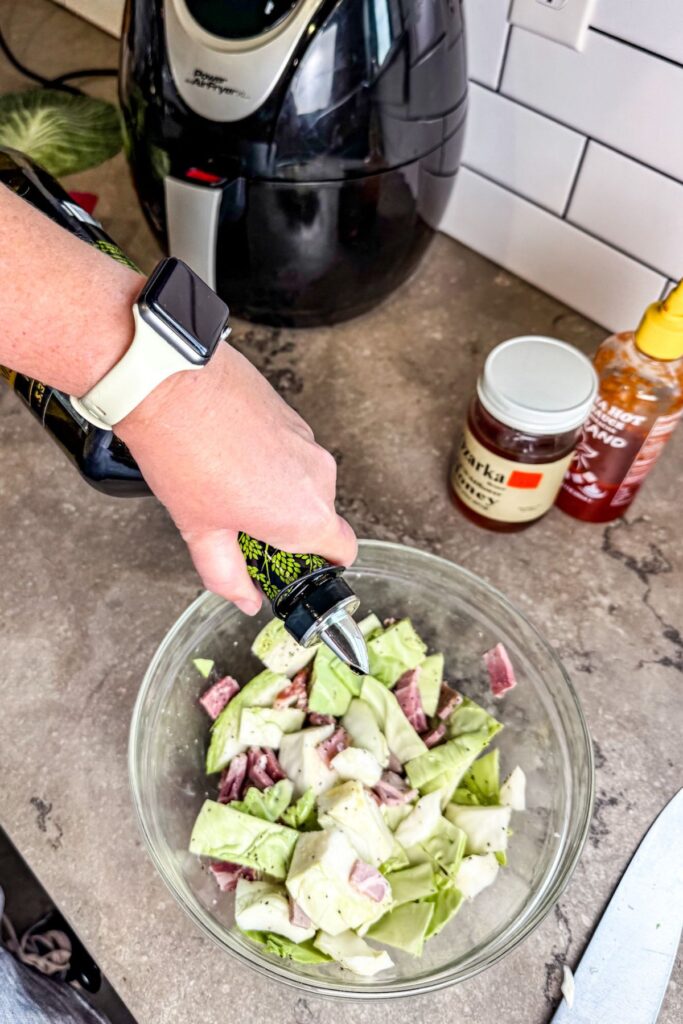 adding olive oil to the cabbage mixture for air fryer cabbage.