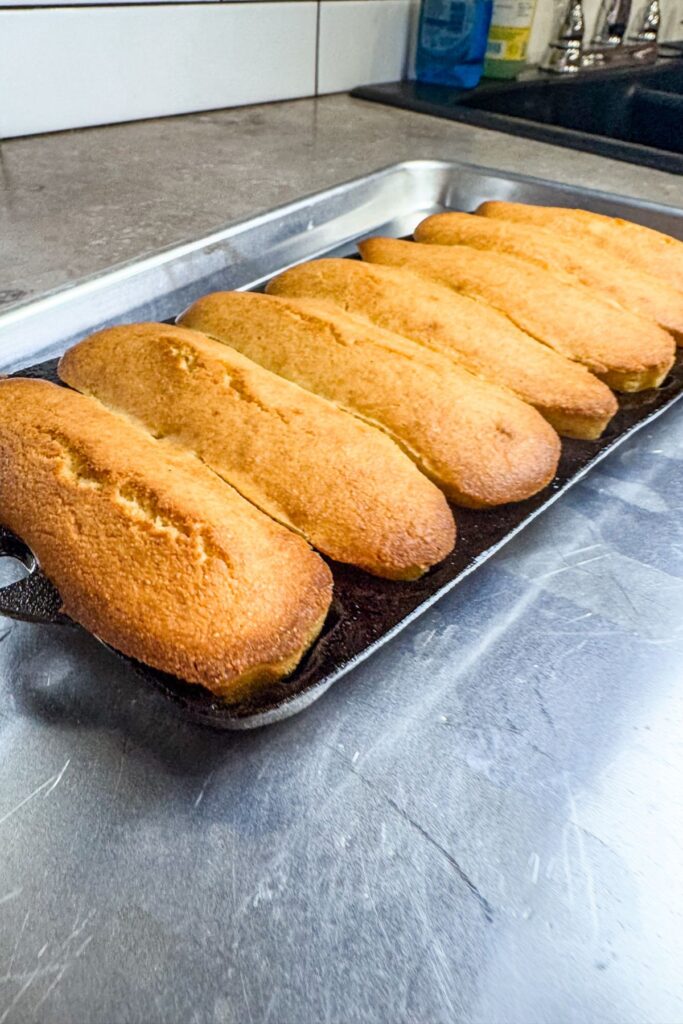 Baked cornbread sticks ready to transfer onto a cooling rack.