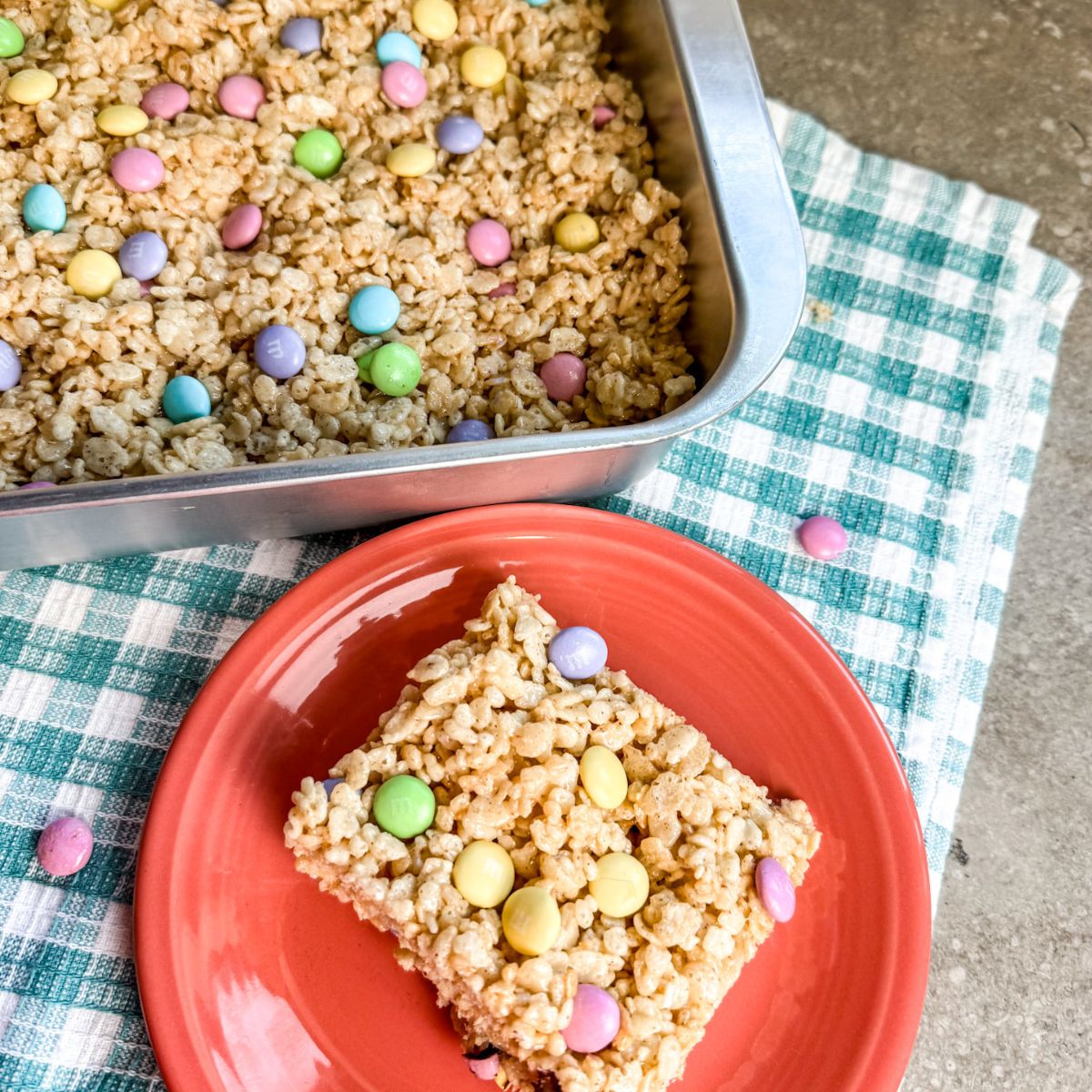 serving-the-M&M-rice-krispie-treats-out-of-a-pan cutting the M&M rice krispie treats and serving them.