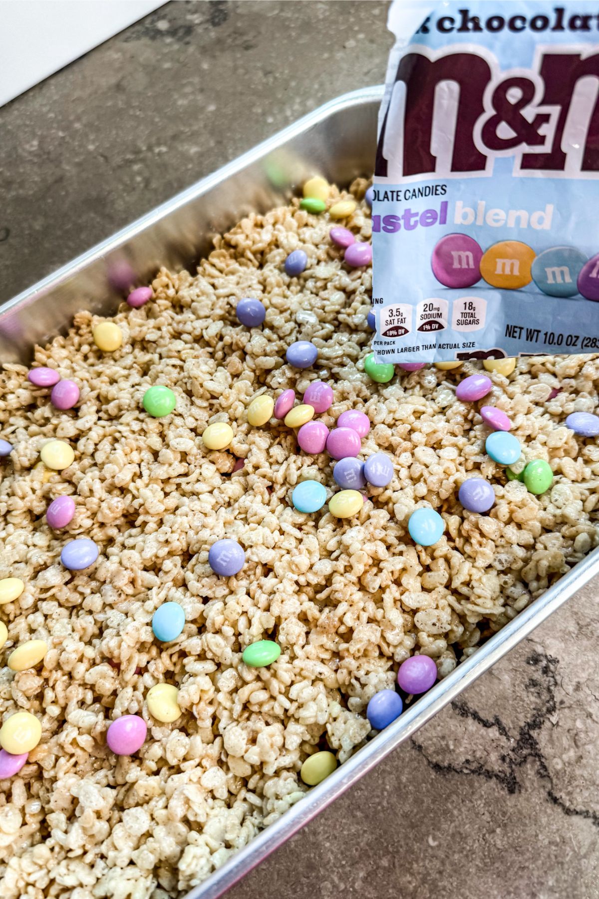 sprinkling M&M onto the rice krispie treats and pressing them into the rice krispies.