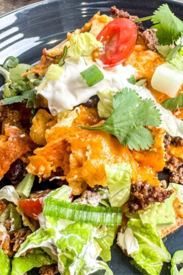 Supreme walking taco casserole served on grey plate.