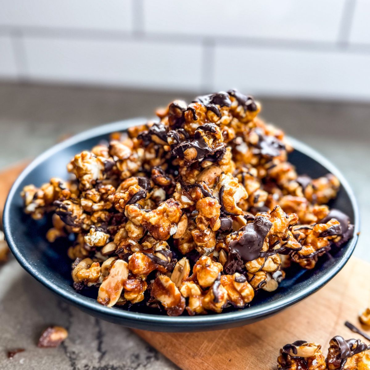 Finished-chocolate-drizzled-carmel-corn-served-in-a-black-serving-bowl Golden brown chocolate drizzled caramel corn is ready to be served.
