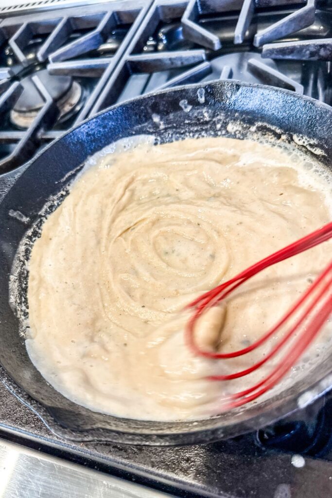 Adding the milk and mixing it in my iron skillet.