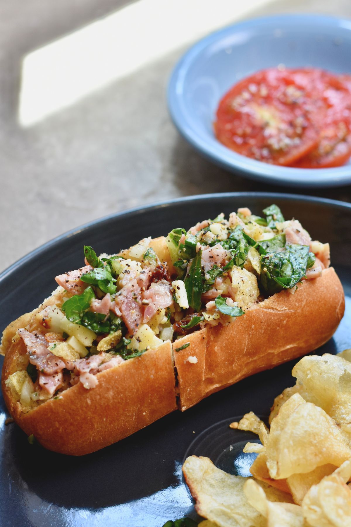 finished-chopped-Italian-sandwich Served the chopped sandwich with a sliced tomato.