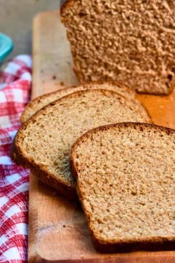 Slicing the wheat bread and serving it to the houseguests.