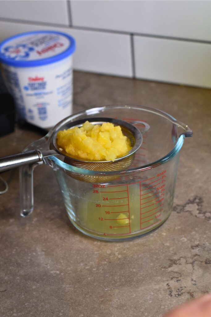 Drain-the-crused-pineapple-into-a-jar Drain the crushed pineapple and add it to the green Jell-O.